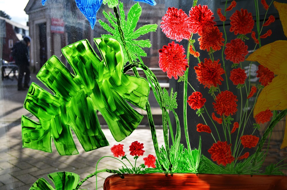 view from inside of painted plants and flowers on shop window