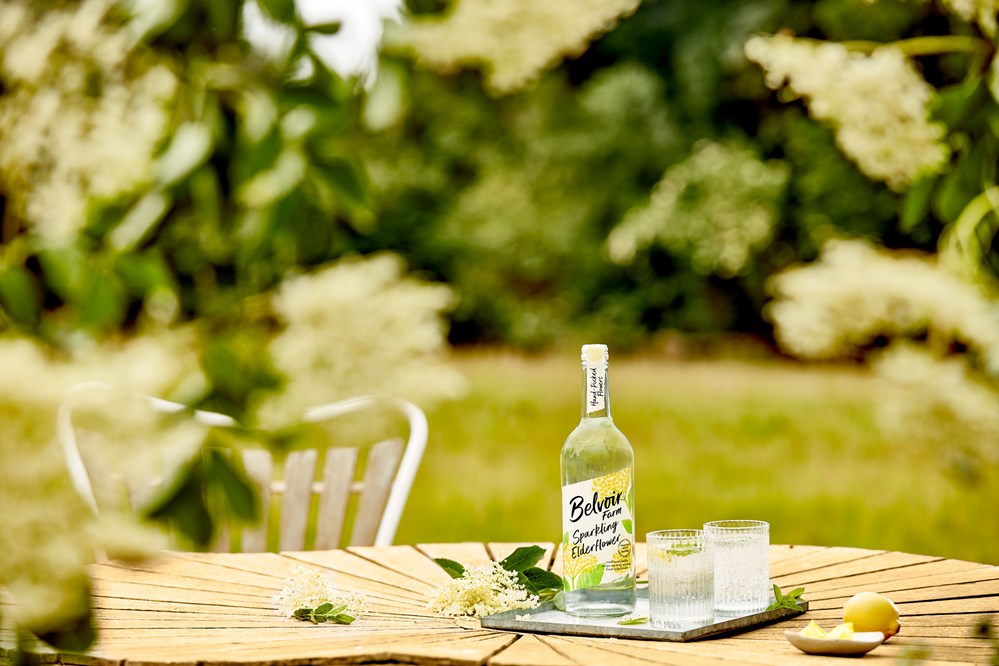 500ml Sparkling Elderflower drink on a garden table with glasses and garnishes