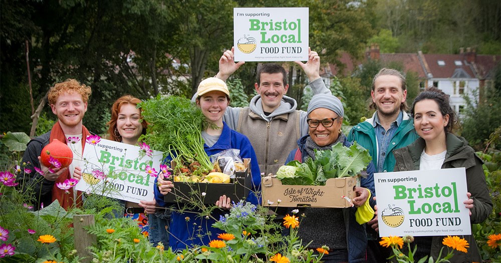 Bristol Local Food Fund team with placards and fresh fruit and vegetable boxes