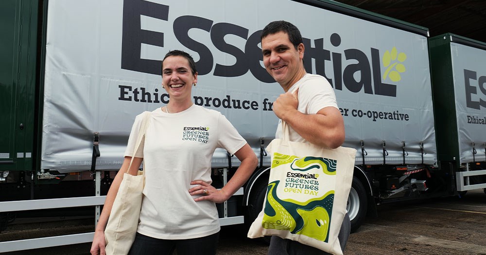 Kate and David at Essential in front of a delivery truck holding Essential tote bags